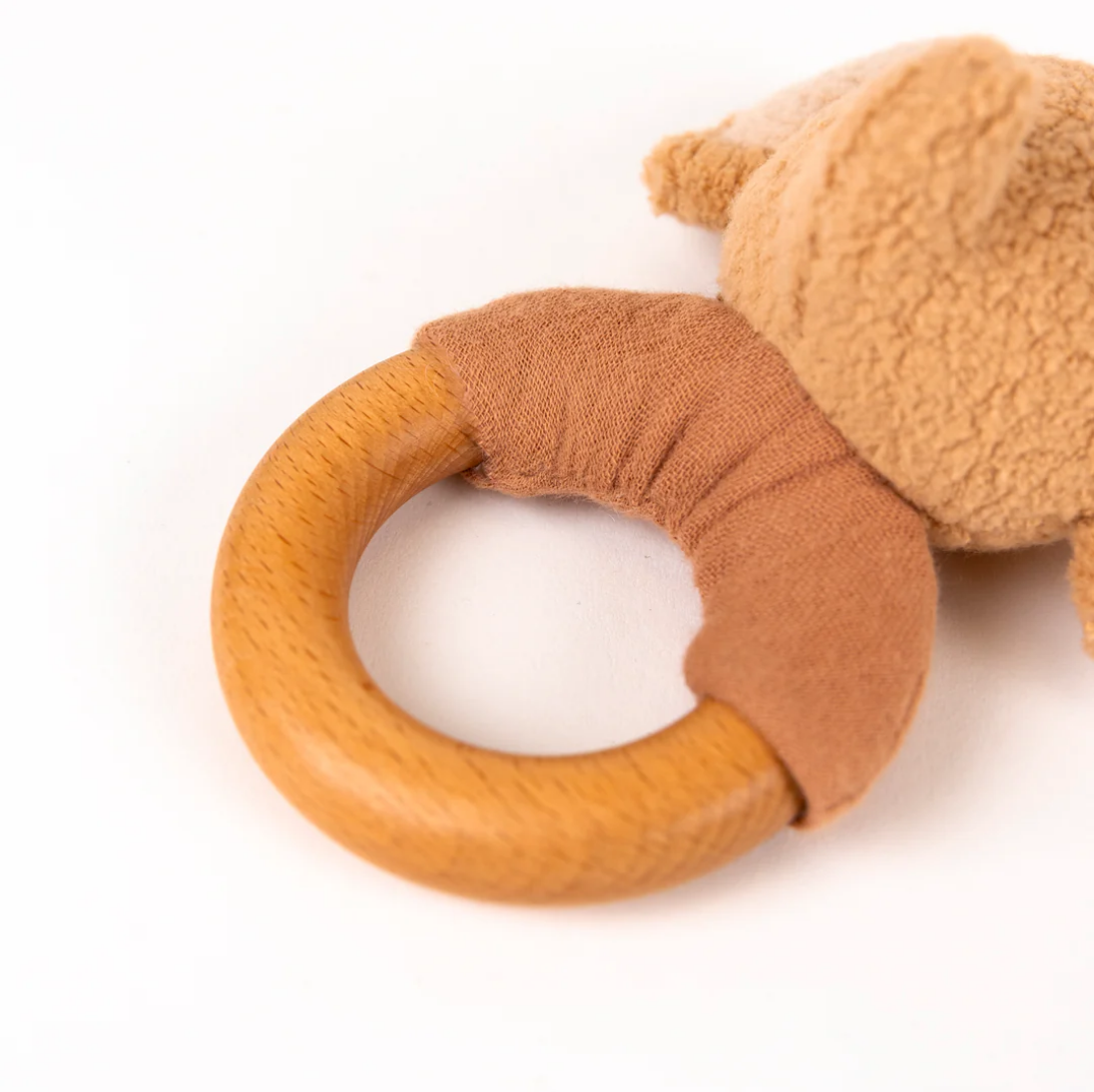 Brown teething ring with a soft toy on a white background