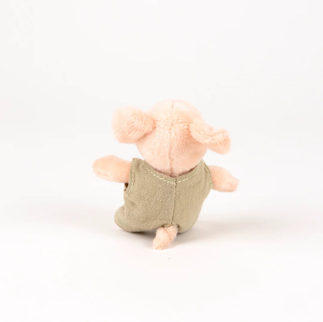 Small plush toy elephant wearing a green outfit on a white background