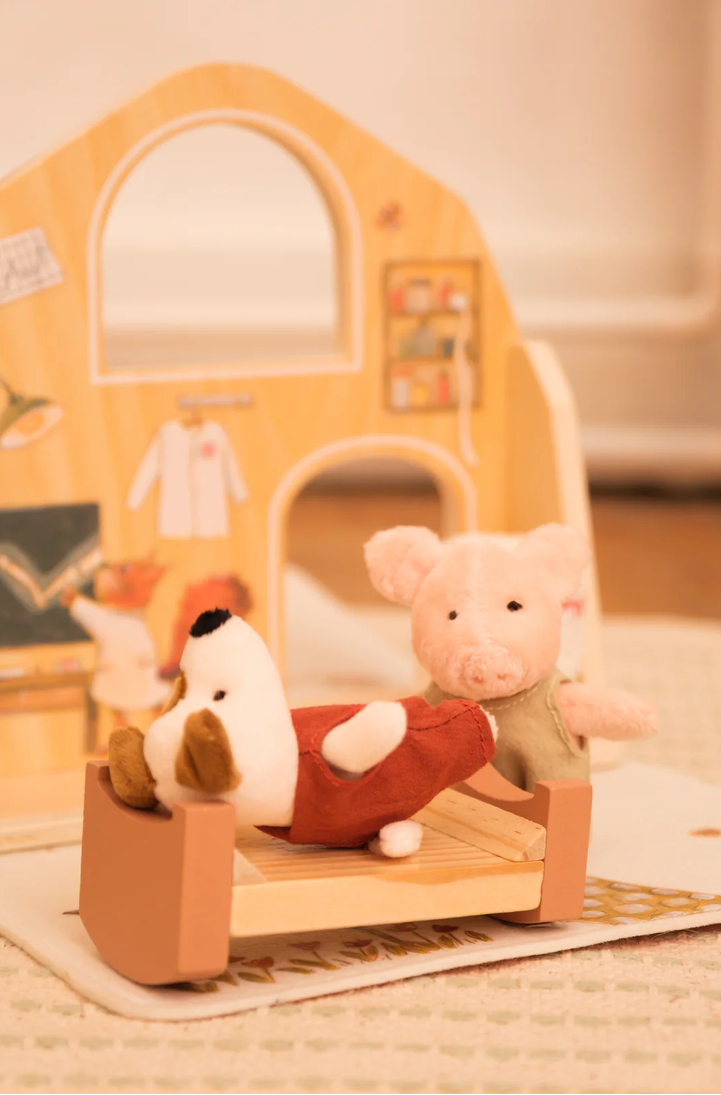 Toy set with a pig and dog in front of a wooden house