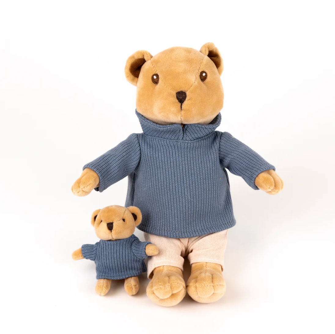 Stuffed bear toy wearing a blue sweater on a white background