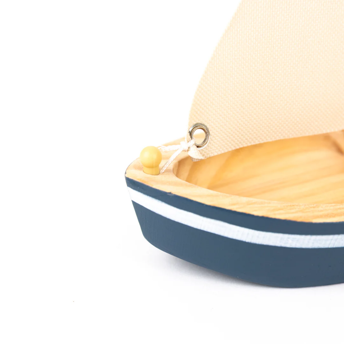 Small model boat with a sail on a white background