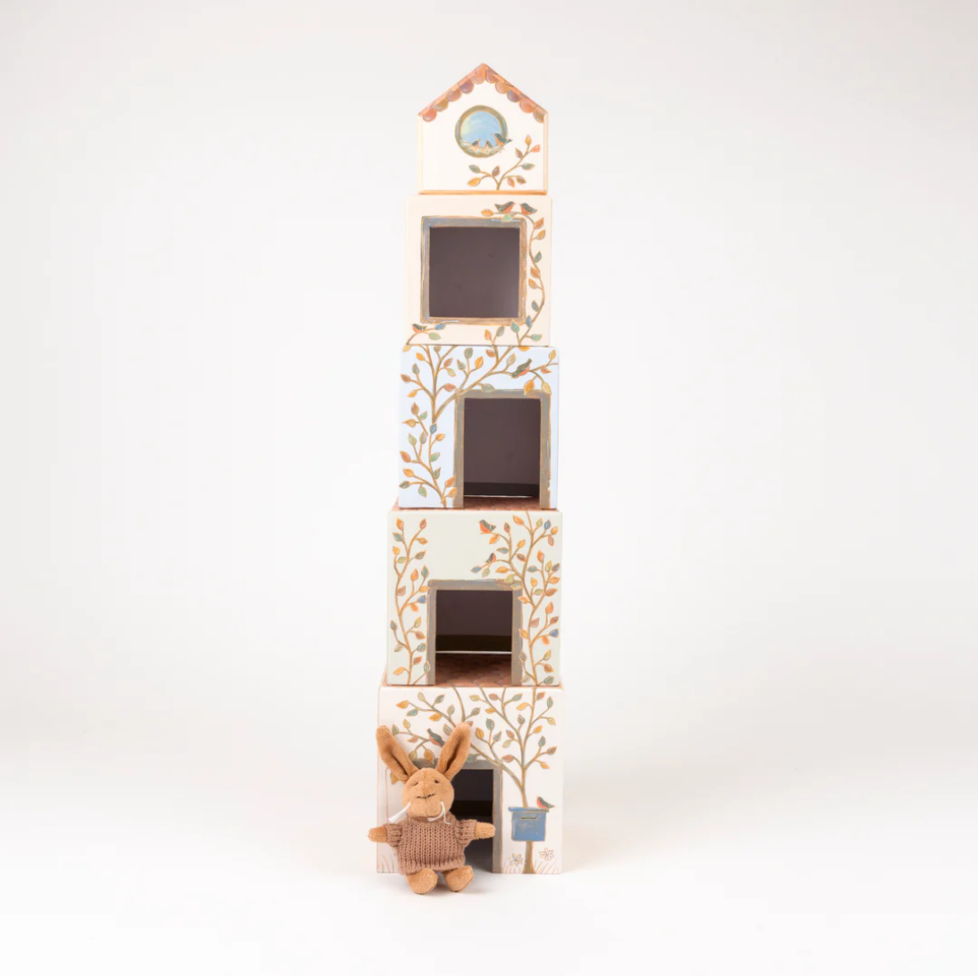 Decorative blocks with tree design and small rabbit figure on a white background