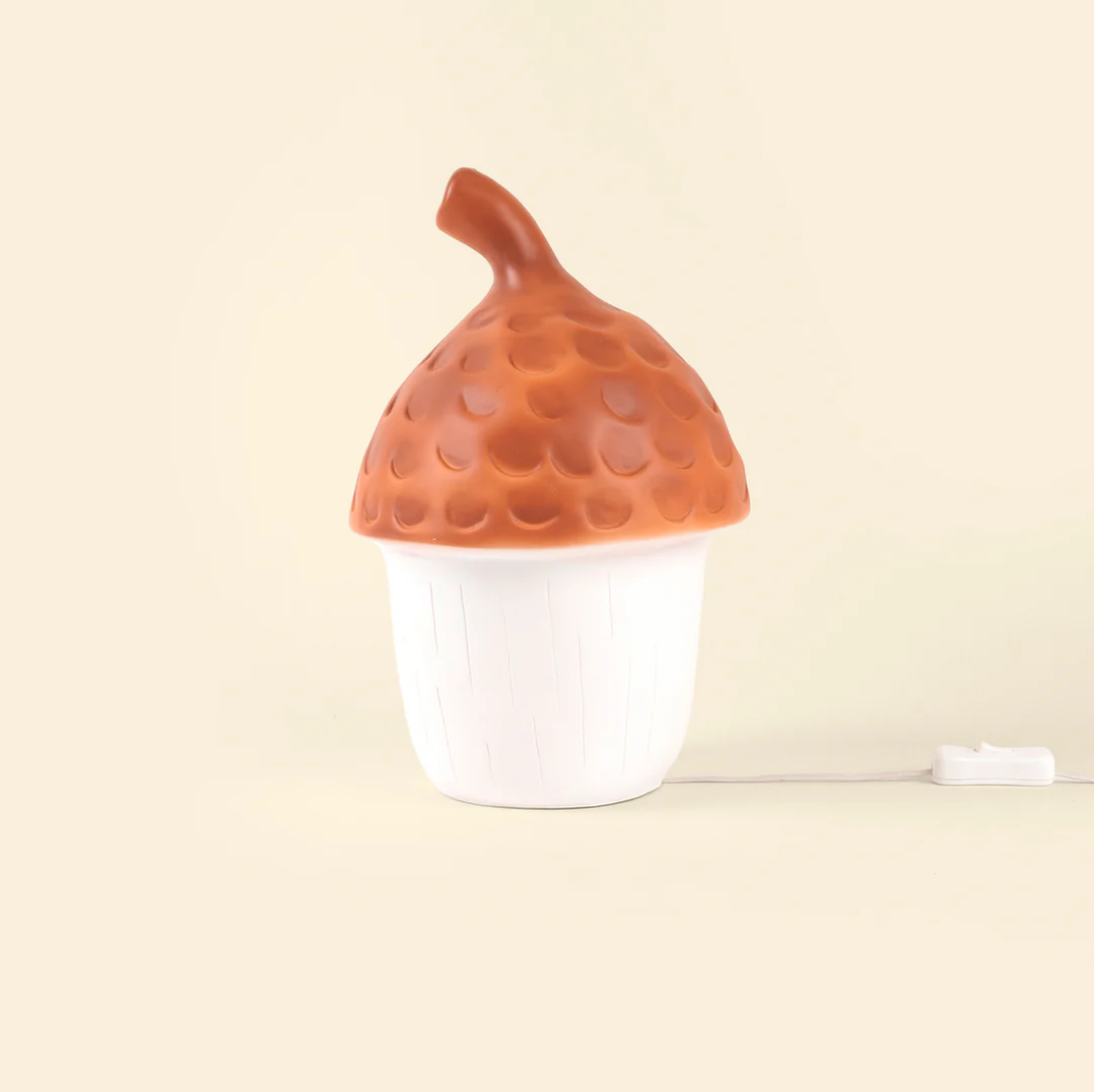 Decorative lamp shaped like an acorn on a beige background