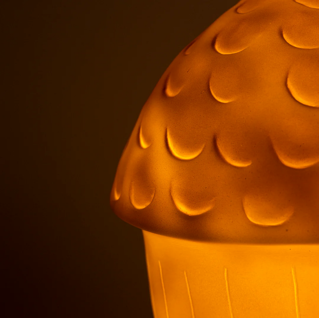 Close-up of a textured orange lamp with a dark background