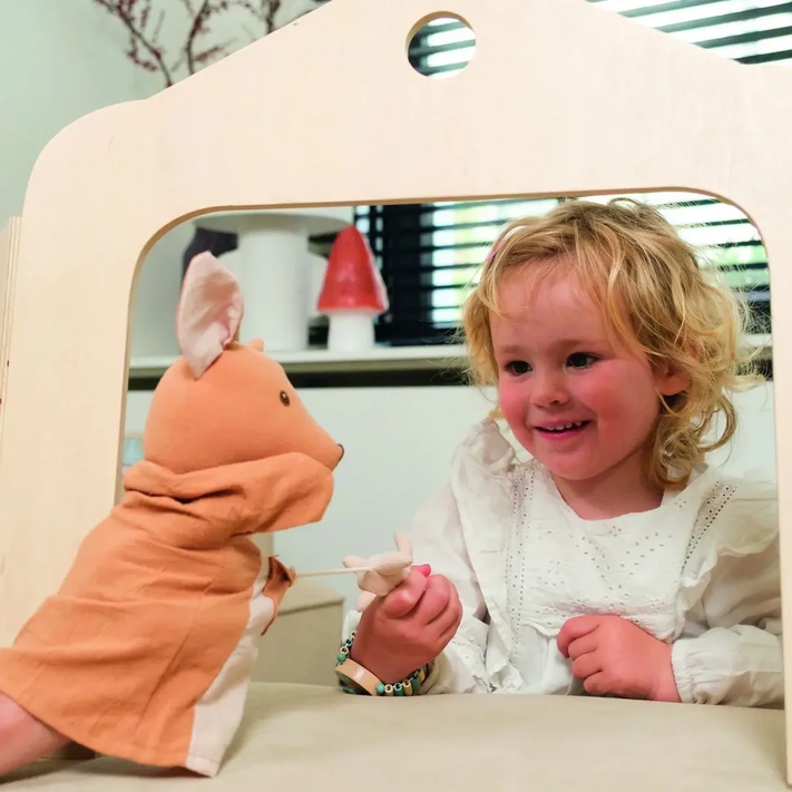 Child playing with a plush toy in front of a mirror