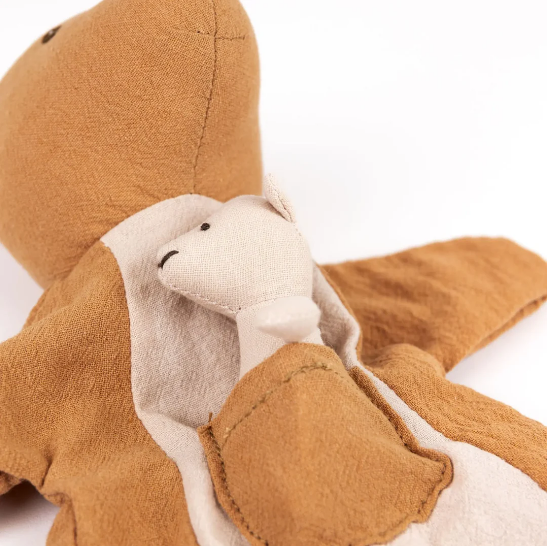 Close-up of a brown and white plush toy with a neutral background