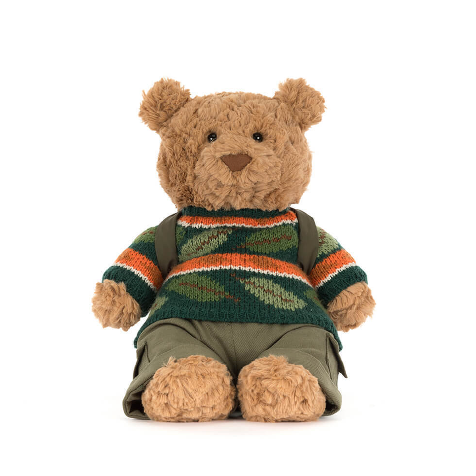 Teddy bear wearing a green sweater with orange accents on a white background