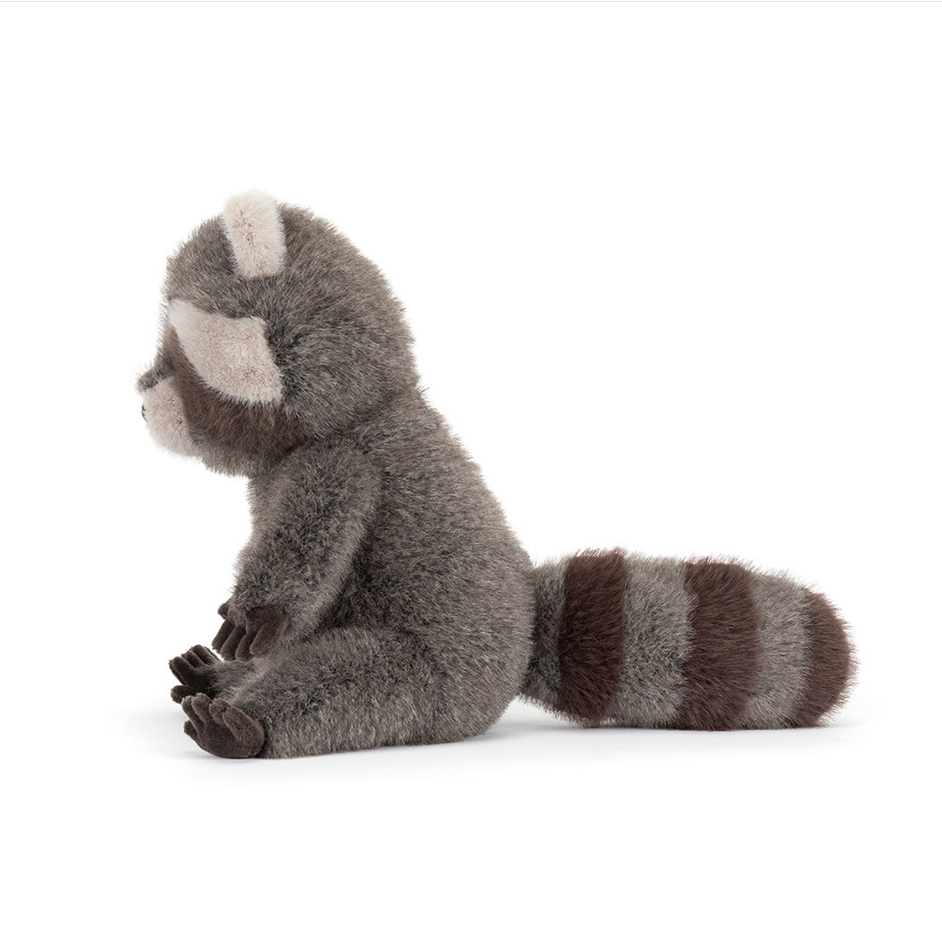 Plush toy raccoon sitting on a white background