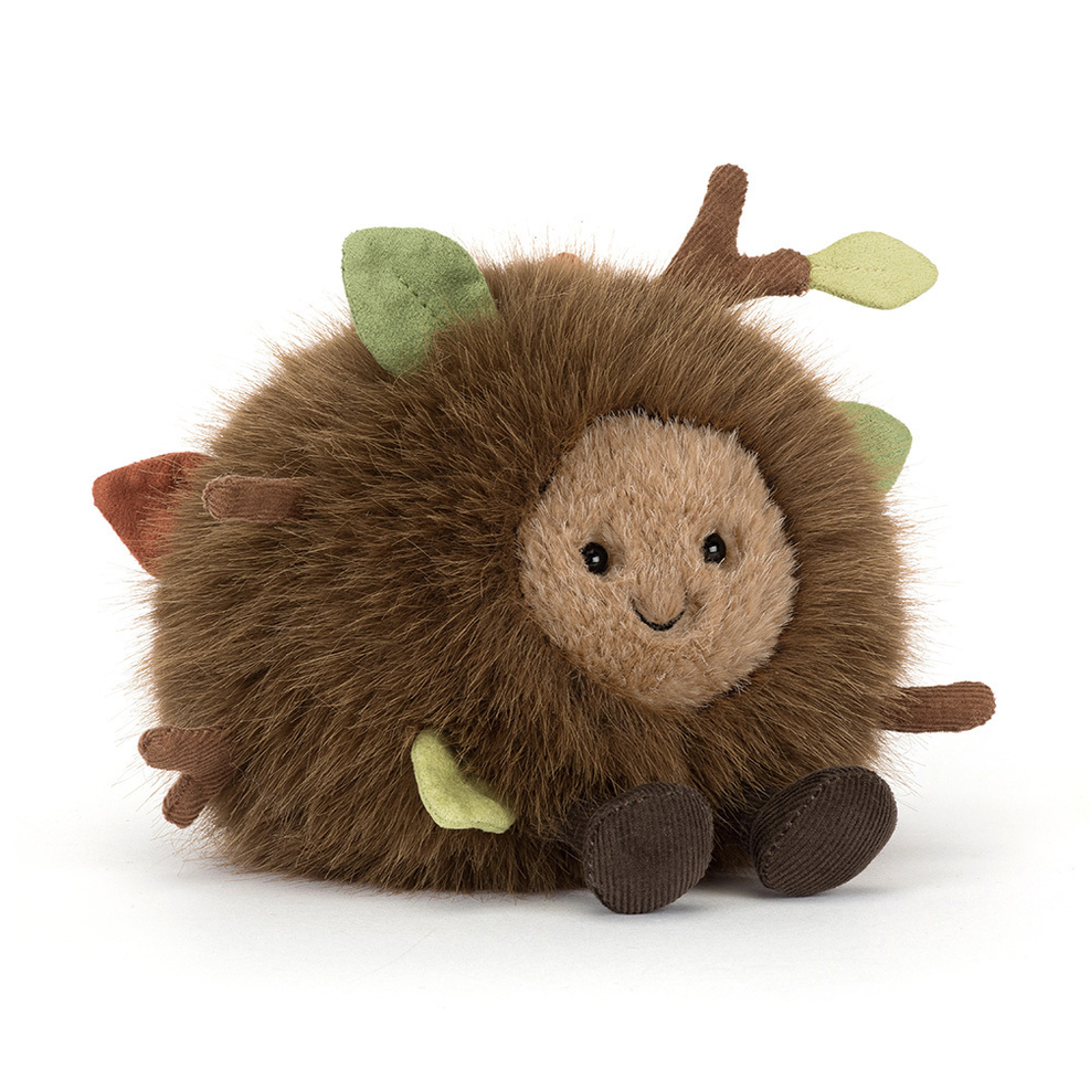 Plush toy hedgehog with green leaves on a white background