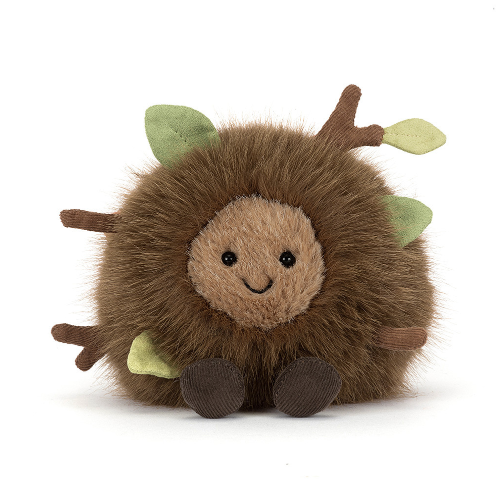 Plush toy creature with green leaves on a white background