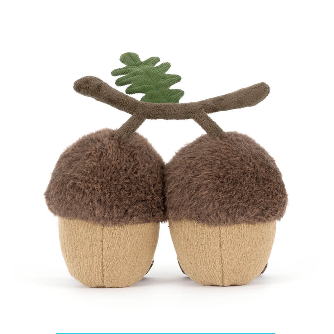 Plush acorn toy with brown fur and green leaf on a white background