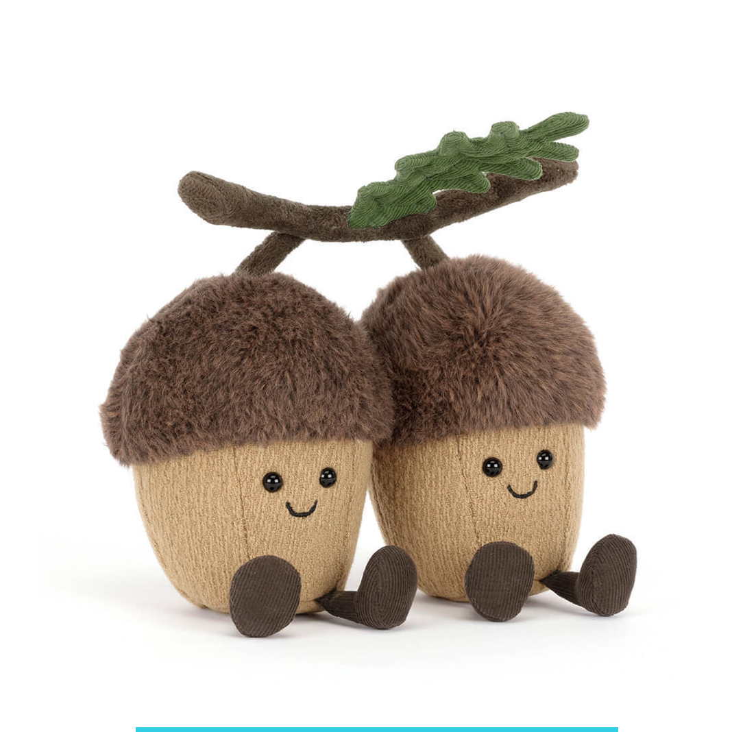 Two plush acorns with faces on a white background