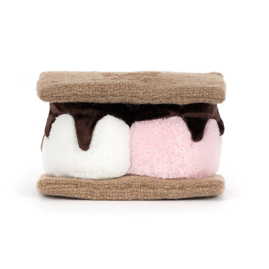 Toy resembling a s'more with brown, white, and pink layers on a white background