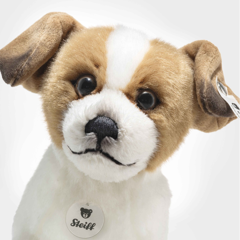Stuffed dog toy with a white and brown color scheme on a light gray background