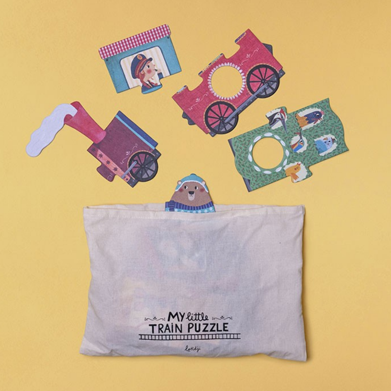 Children's train puzzle with pieces and a storage pouch on a yellow background