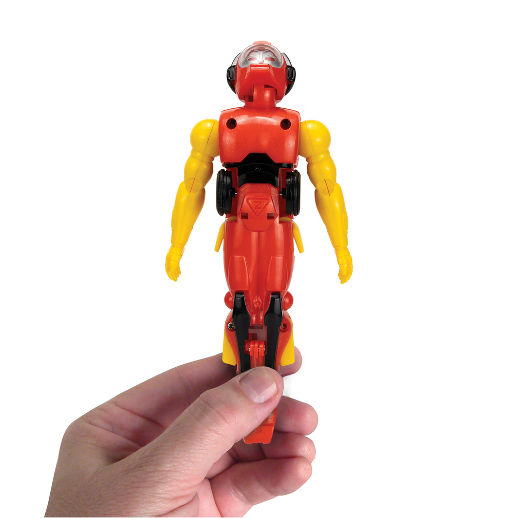 Hand holding a red and yellow robot toy against a white background