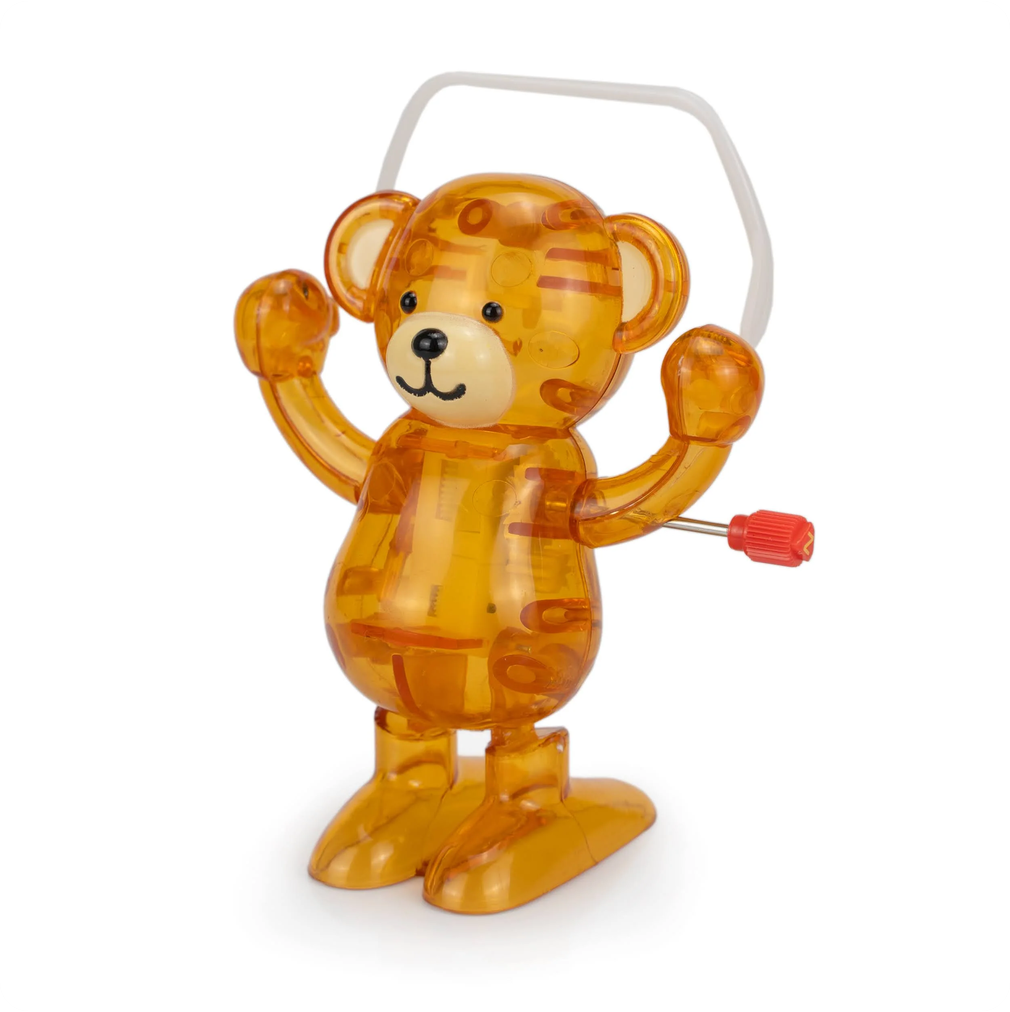 Transparent orange bear toy with a red knob on a white background
