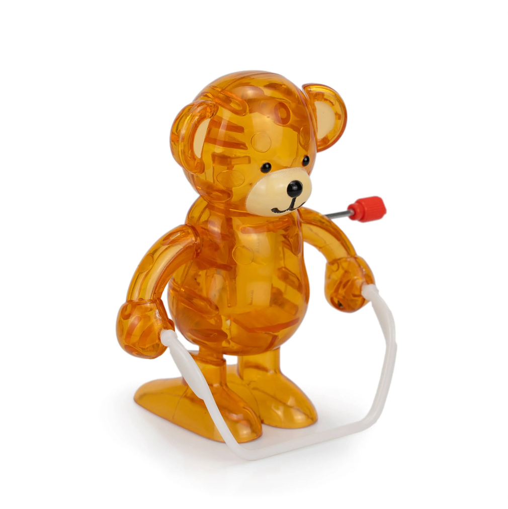 Transparent orange bear toy with a red knob and white rope on a white background