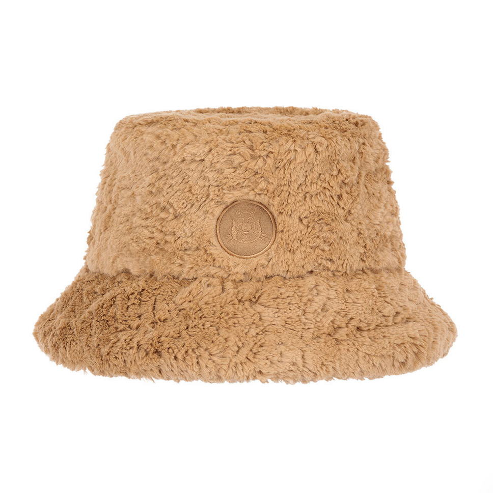 A light brown fluffy bucket hat with a circular patch on the front