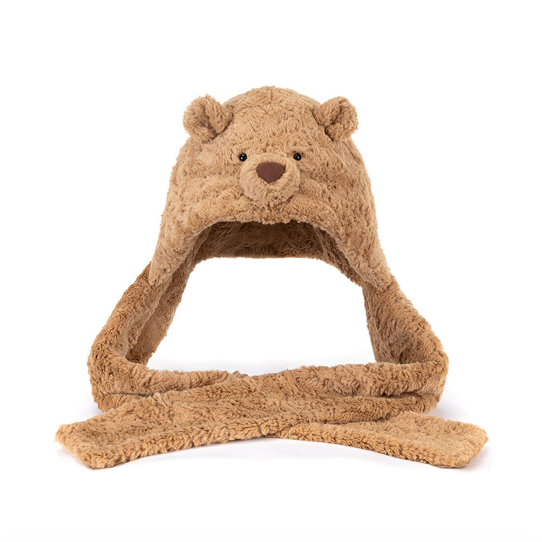 A plush teddy bear hat with attached ear flaps and a matching scarf, shown on a plain white background.
