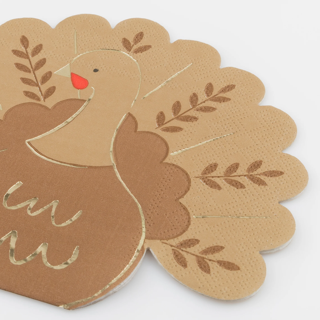 A close-up of a Thanksgiving-themed paper napkin featuring a turkey design in shades of brown and beige with a small red beak accent.