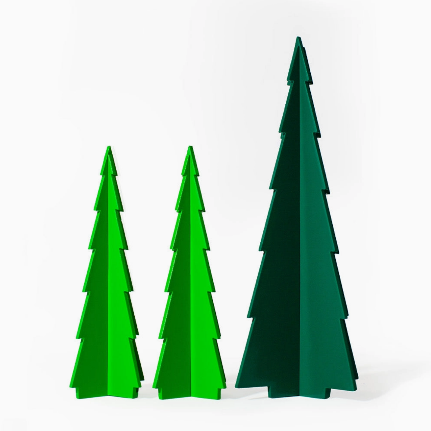 Three stylized, layered  trees in shades of green, displayed against a clean white background.
