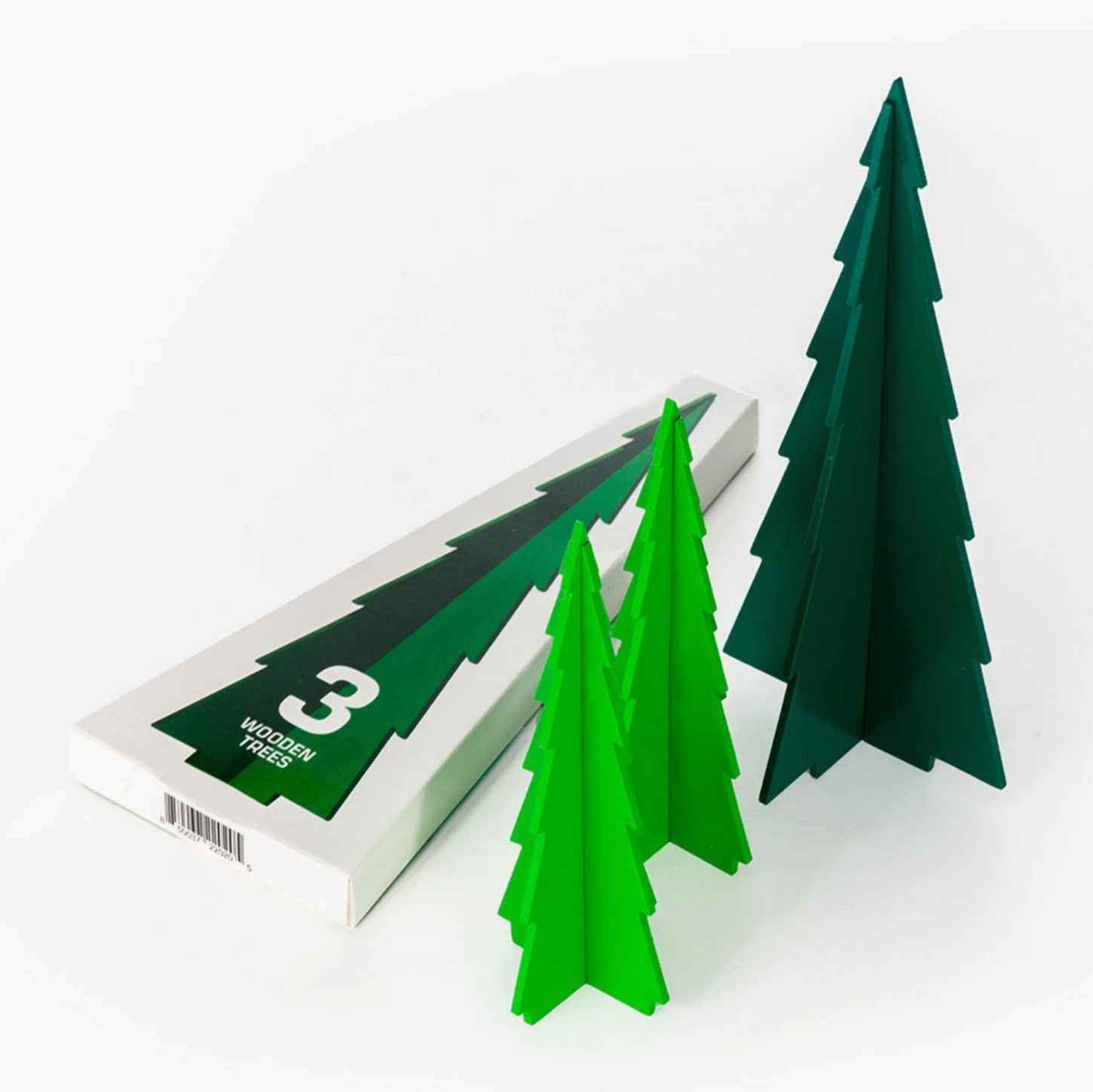 Three green geometric trees of varying sizes displayed next to their white and green retail packaging box on a clean white background.