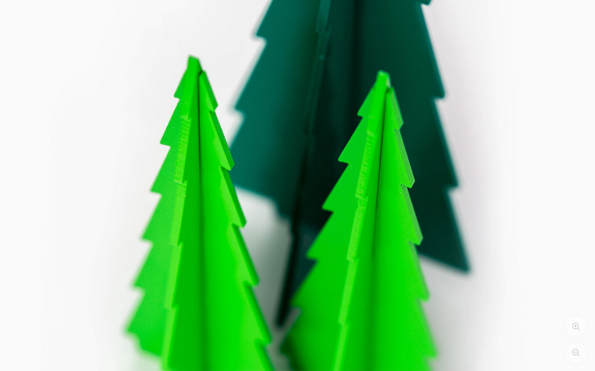 Three green wooden trees of different heights arranged against a plain white background.