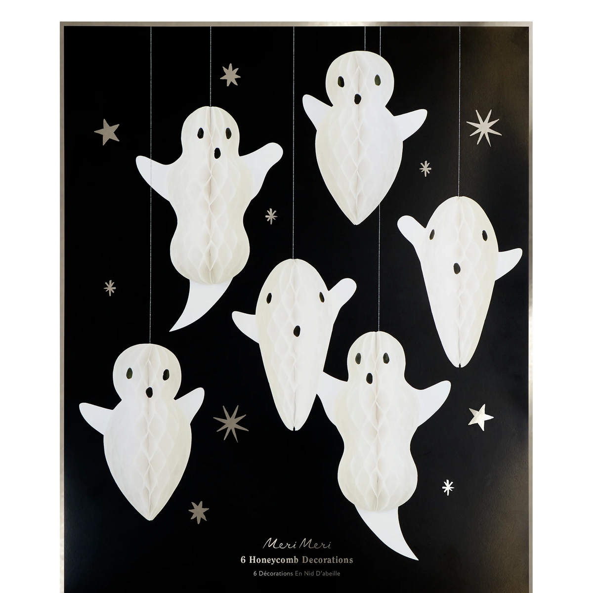A set of six white hanging honeycomb ghost decorations with black eyes, displayed against a black background with small silver starburst accents. The brand name 'Meri Meri' is printed at the bottom.