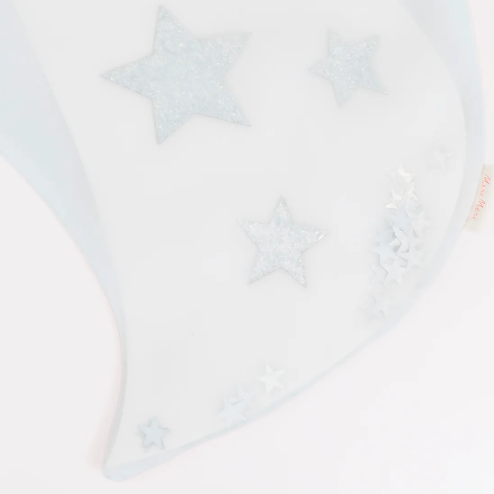 A close-up of a white fabric accessory, likely a baby blanket or soft wrap, decorated with glittery star and snowflake appliqués in pale blue and white.
