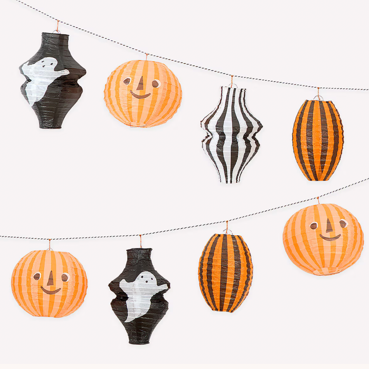Halloween hanging lantern garland with four decorative paper lanterns strung across a light gray background. The set includes orange pumpkins and black-and-orange striped lanterns, with ghost cutouts in black and white inside two black lanterns.