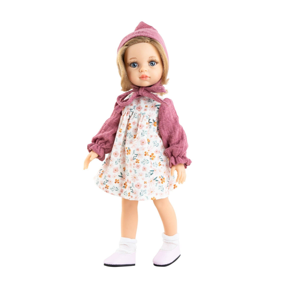 A doll with blonde hair wearing a pink hat, a floral dress, and a mauve cardigan, standing against a white background.