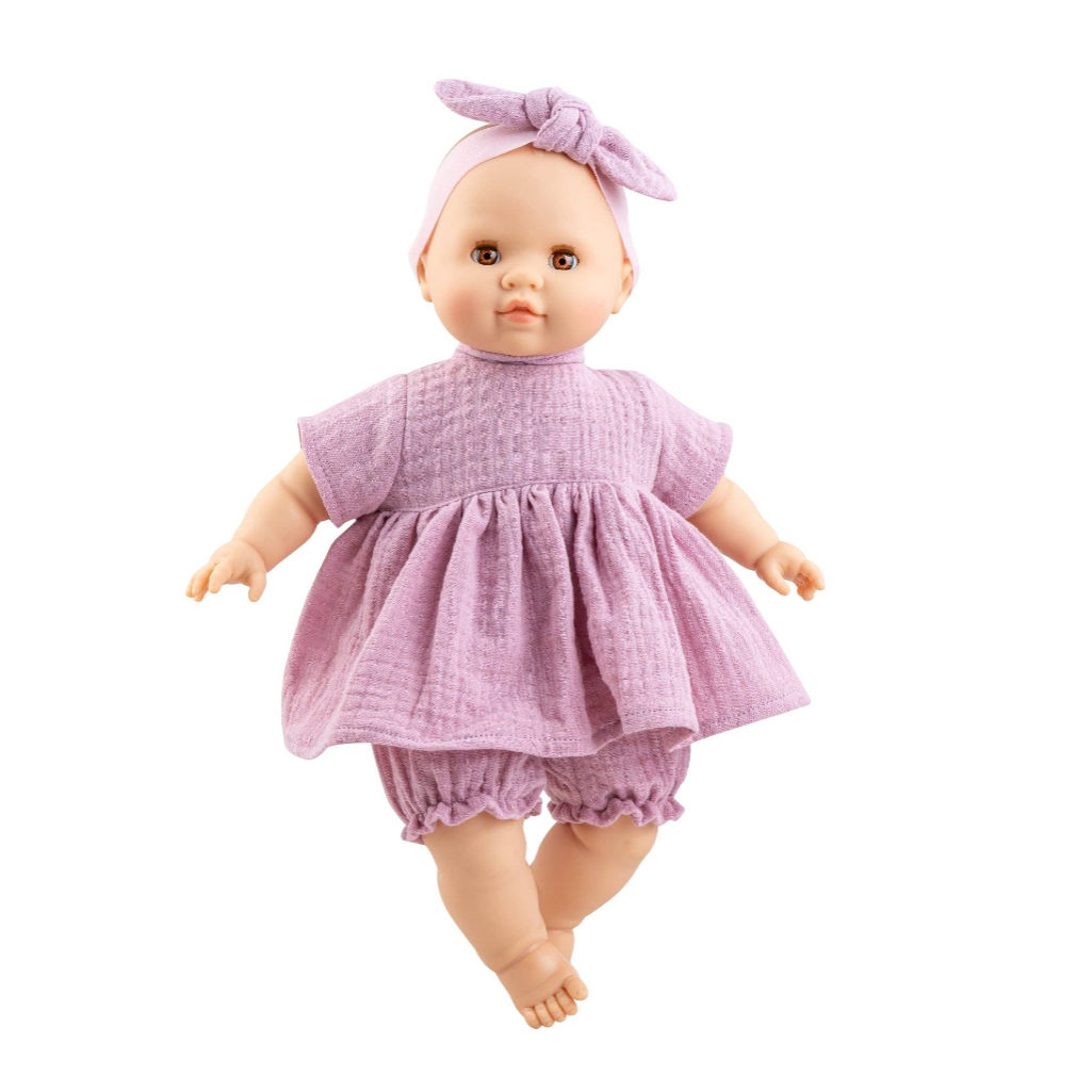 A baby doll wearing a textured light purple short-sleeve dress, matching ruffled bloomers, and a bow headband, isolated on a white background.