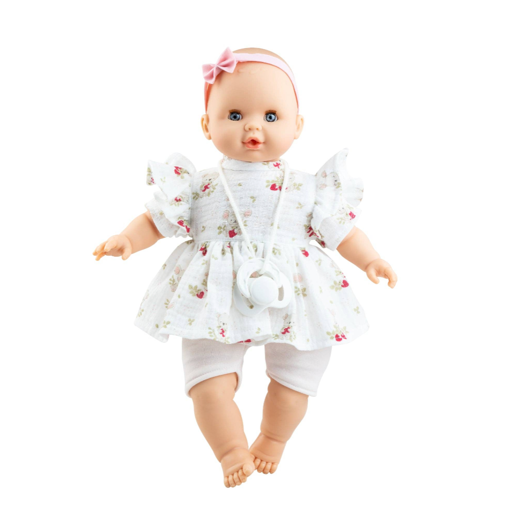 A baby doll with blue eyes wearing a white floral dress, white pants, and a pink bow headband