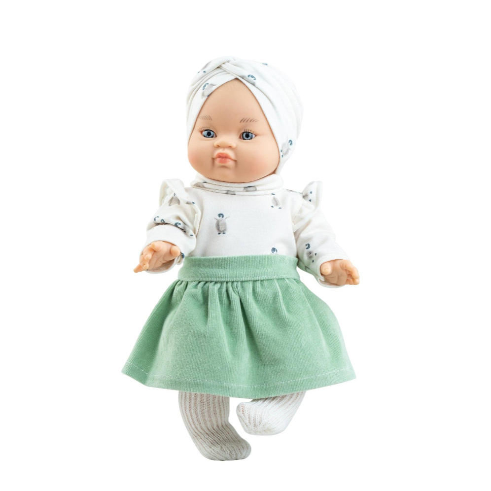 A baby doll with a realistic face, wearing a white patterned long-sleeve top, a light green skirt, white socks, and a white bonnet, shown against a plain white background.