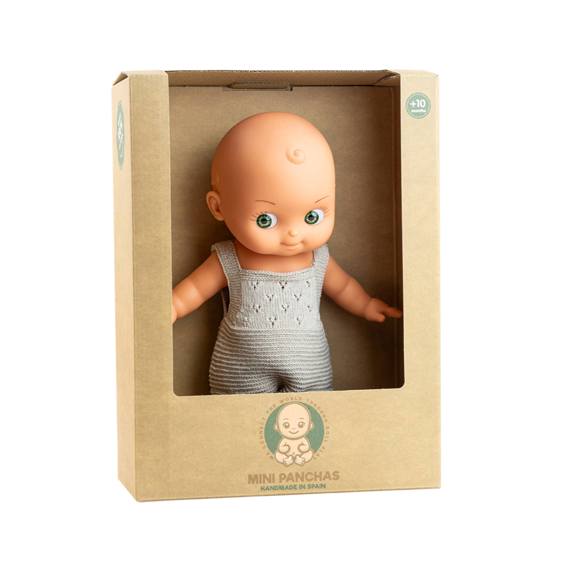 A baby doll with a bald head and blue eyes, wearing a gray knit romper, displayed inside a brown cardboard window box labeled 'MINI PANCHAS'.