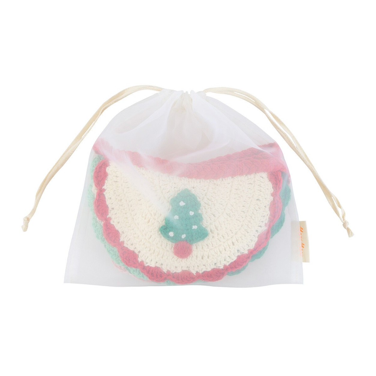 A white mesh drawstring bag containing a round handmade crochet bib or bandana-style textile piece in cream, pink, and mint green with a small tree motif, shown on a plain white background.