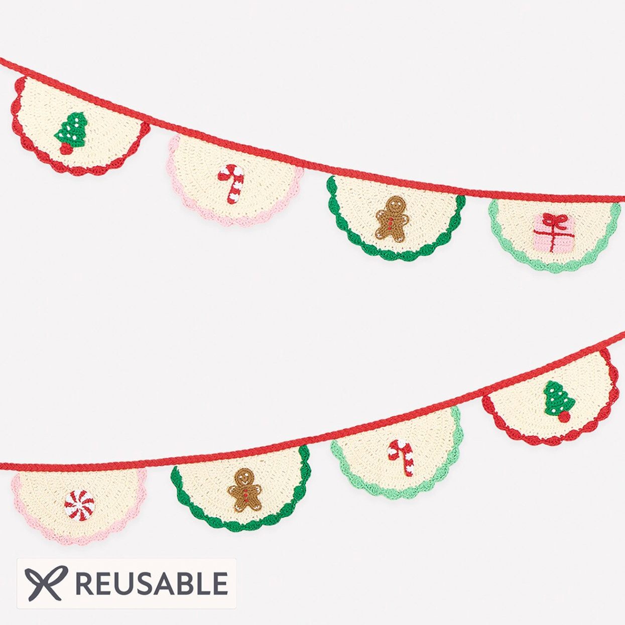 A reusable Christmas-themed bunting banner set with alternating cream pennants decorated with red scalloped edges and festive motifs including gingerbread men, candy canes, pine trees, and Japanese characters, shown on a light gray background with a 'REUSABLE' label at the bottom.