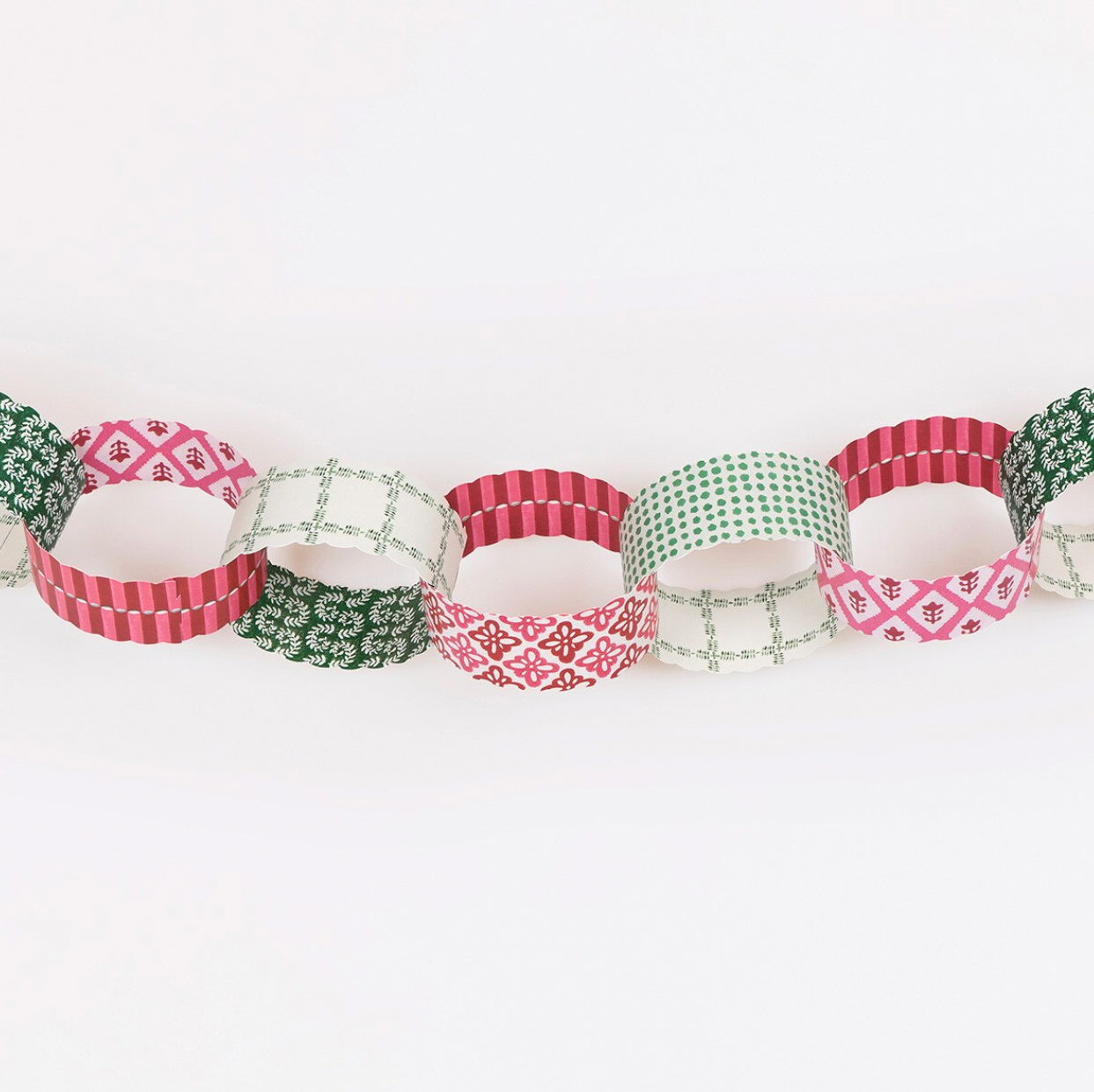 A paper chain garland made of alternating paper loops with festive patterns, including red and white stripes, green and white geometric designs, and pink and white motifs, displayed on a clean white background.