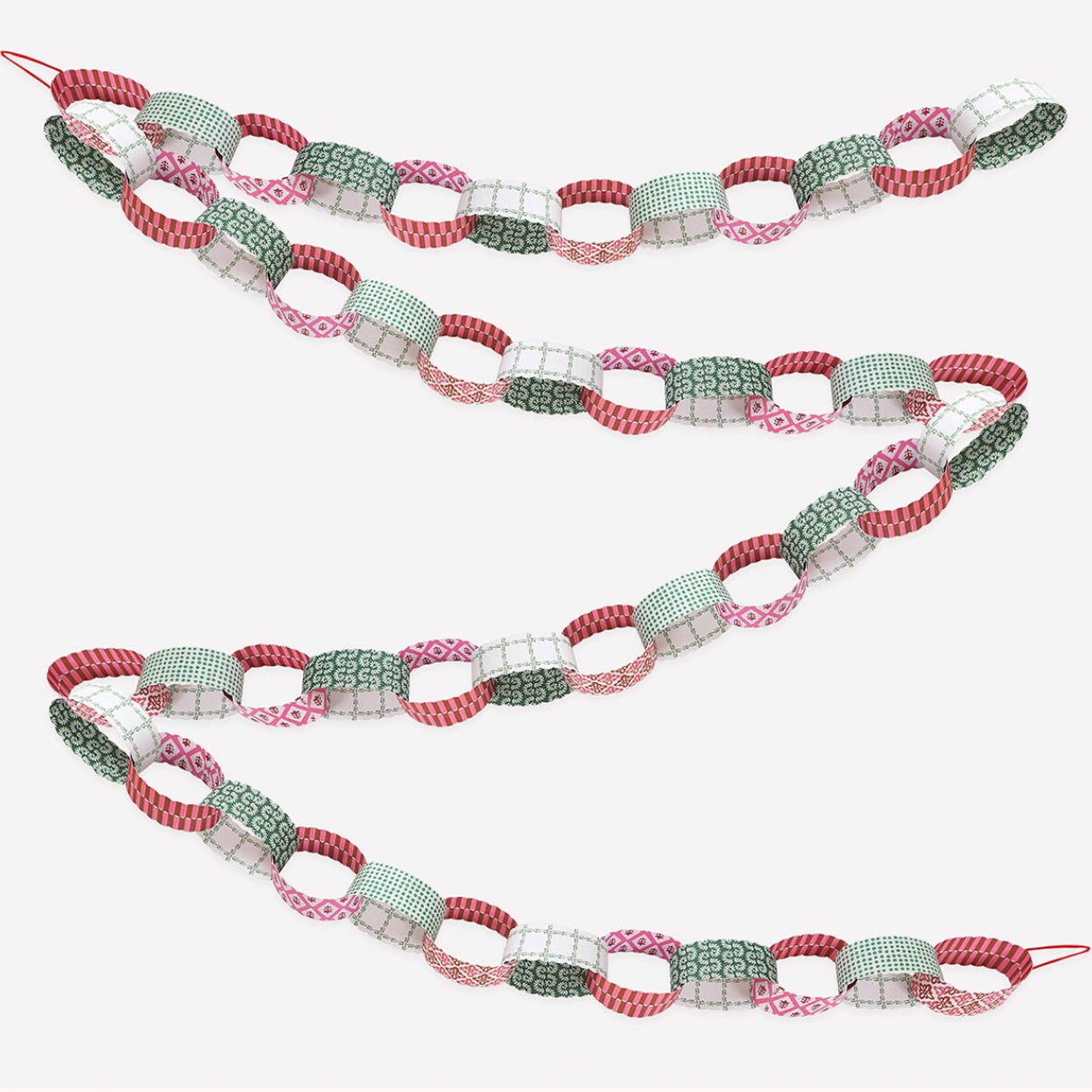 A decorative garland made of alternating patterned paper links in red, sage green, pink, and white, arranged in three curved rows on a plain white background.