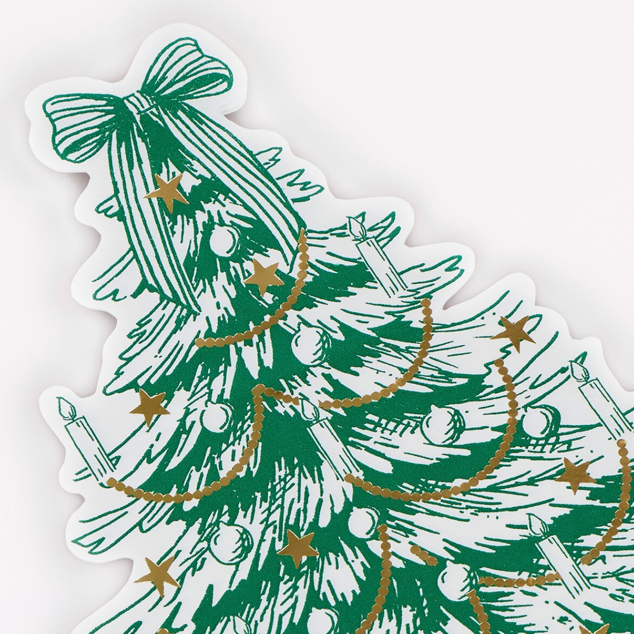 A Christmas tree-shaped napkin with a green hand-drawn tree design, gold garland, stars, ornaments, and white border on a light background.