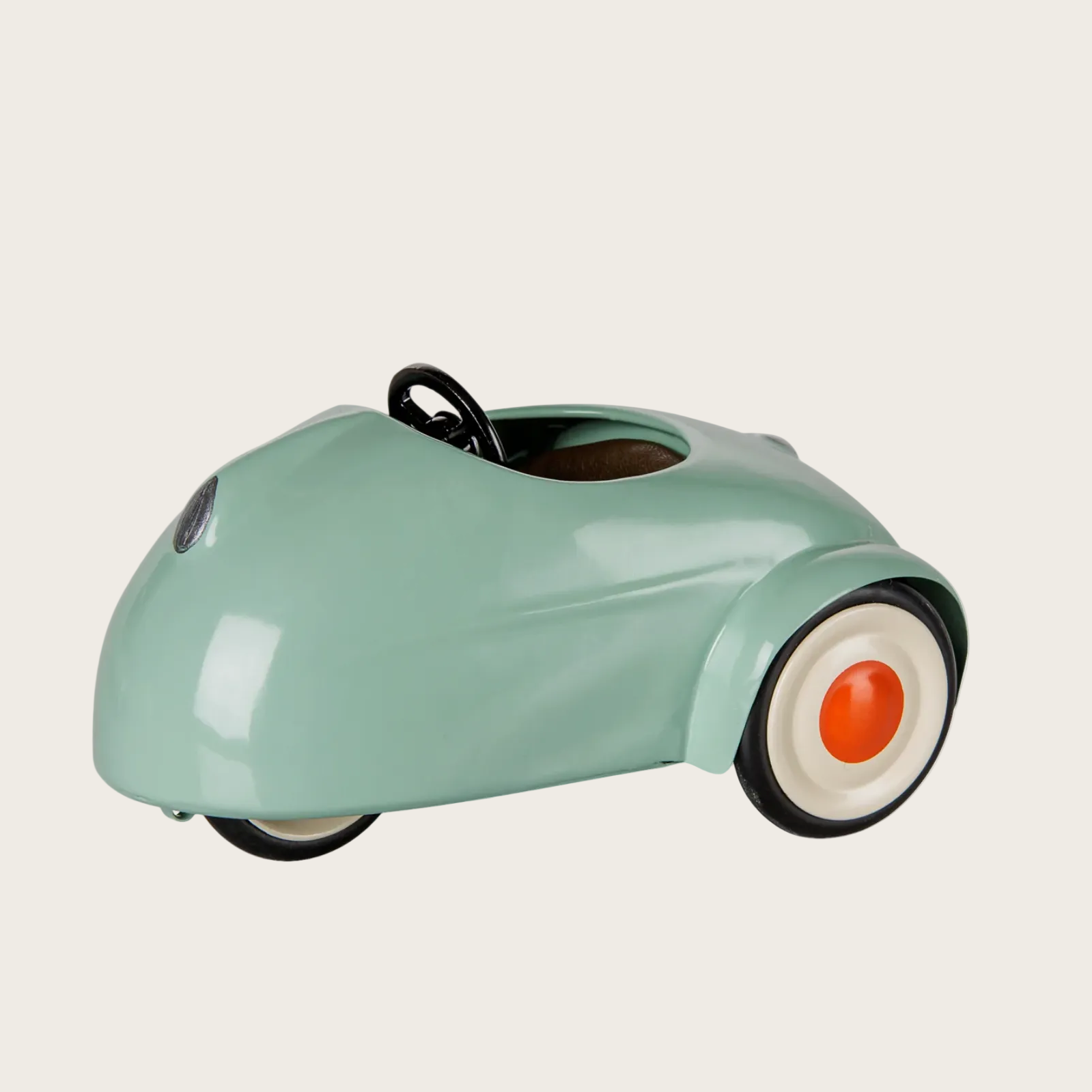 A webpage screenshot showing a mint green retro-style metal toy car with orange wheels