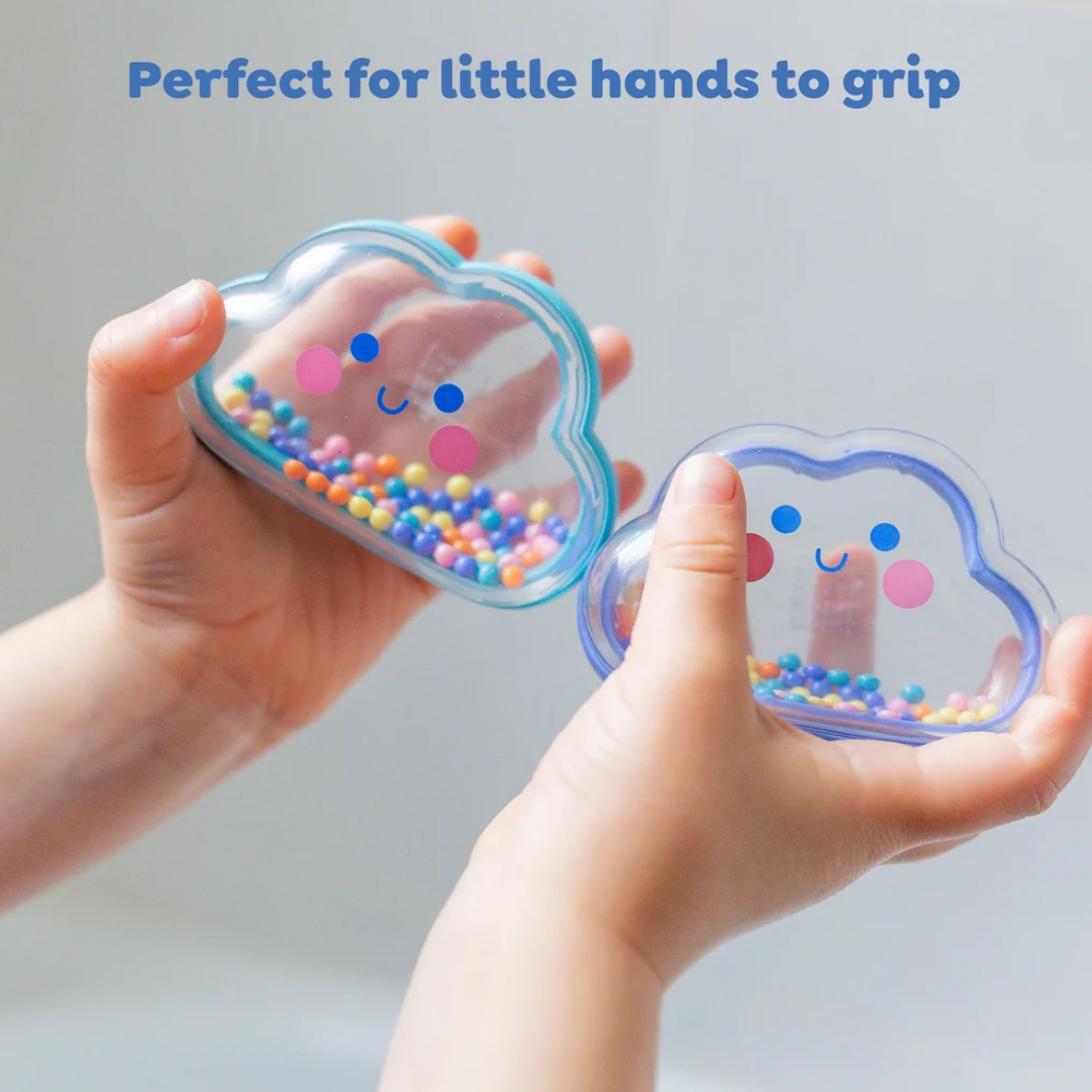 Two small cloud-shaped sensory containers filled with multicolored beads are held in two child's hands, with the text 'Perfect for little hands to grip' at the top.