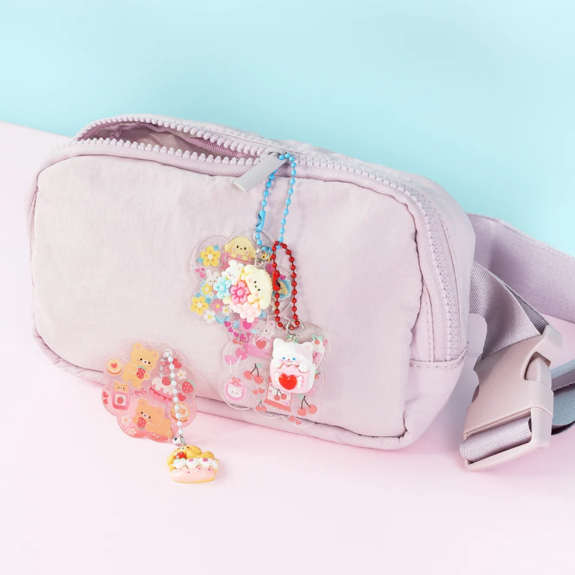Pink waist bag with cute keychains on a light blue background