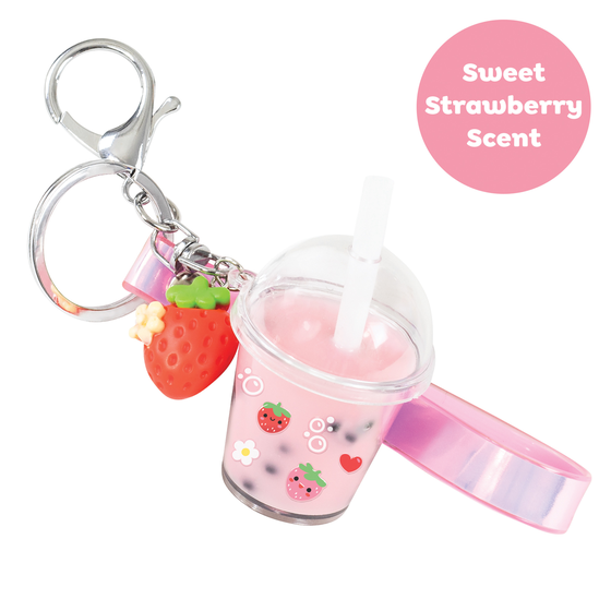 A miniature pink bubble tea cup keychain with a clear lid, white straw, strawberry charm, and silver clasp on a white background, with a pink circle label reading 'Sweet Strawberry Scent'.