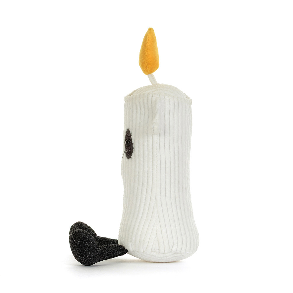 A white ribbed plush candle toy with a yellow flame and black stitched facial features, photographed on a clean white background.
