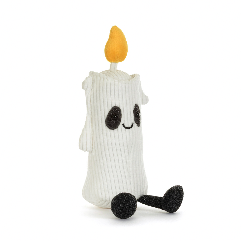A white ribbed knit candle-shaped plush toy with a yellow flame on top, black embroidered eyes and mouth, and black feet, shown on a plain white background.
