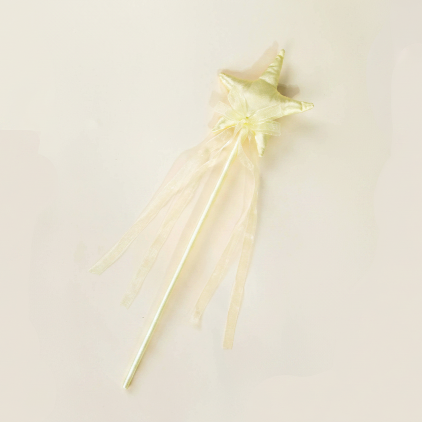 A pale yellow star-shaped wand with sheer organza ribbon tails, displayed diagonally on a light cream background with a black dotted border.