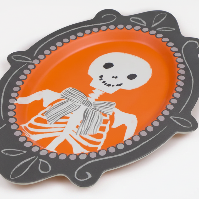 Decorative plate with skeleton design on an orange background