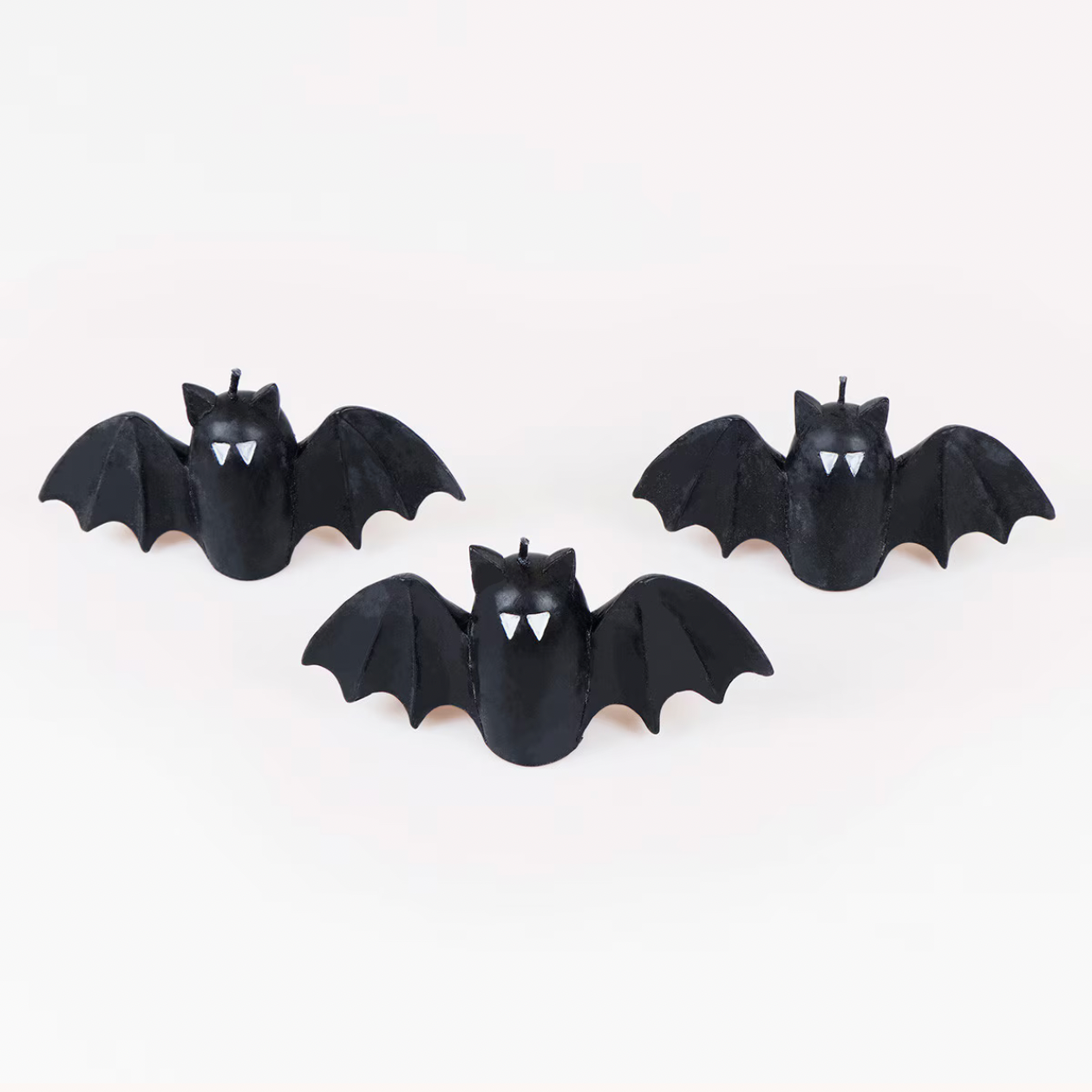 Three black bat-shaped hair clips with white vampire eyes and fangs, arranged on a plain white background.